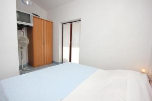 a bedroom with a white bed and a window at Studio Punta kriza 383b in Punta Križa