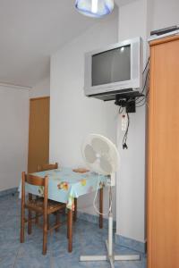a room with a table and a tv on a wall at Studio Punta kriza 383b in Punta Križa
