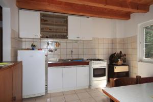 La cuisine est équipée de placards blancs et d'un réfrigérateur blanc. dans l'établissement Secluded fisherman's cottage Krknata, Dugi otok - 397, à Žman