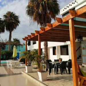 eine Terrasse mit einem Tisch und Stühlen sowie ein Gebäude in der Unterkunft Hotel La Posada Del Ingles in Chiclayo