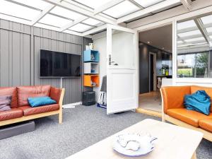 uma sala de estar com dois sofás laranja e uma televisão em Holiday home Skagen LXVI em Skagen