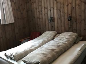 two beds in a room with wooden walls at Holiday home Skare in Skare