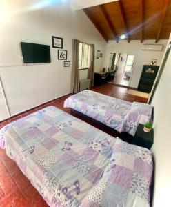 a bedroom with two beds and a tv in it at Hermosa Casa en el corazón de Chacras de Coria in Chacras de Coria