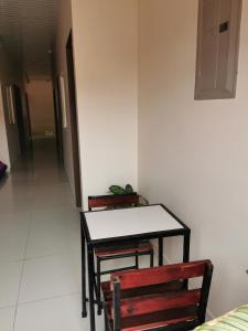 a table and a bench in a room with a hallway at Hotel Pecos Bill in San José