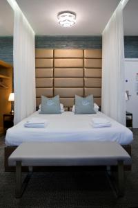 a bedroom with a large white bed with blue pillows at Horizon Hotel in Ayr