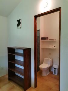 bagno con servizi igienici, lavandino e specchio di Mira Olas Cabins a Pavones