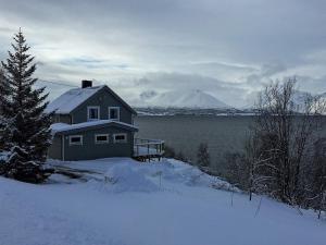 a house in the snow with a mountain in the background at 6 person holiday home in Olderdalen in Olderdalen