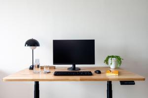 a desk with a computer monitor and a keyboard at Sentral Old Town in Scottsdale