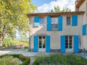 an exterior of a house with blue shutters at Bastide with pool and panoramic views in Ménerbes