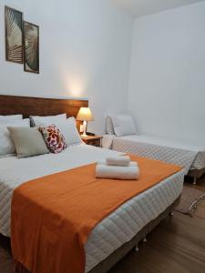 two beds sitting next to each other in a room at Pousada Candelabro in Tiradentes