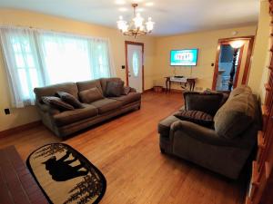 a living room with two couches and a tv at B And A Lake Cottage in Luray