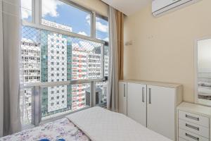 une chambre avec un lit et une grande fenêtre dans l'établissement Modern Apartment perto 1 block Copacabana Beach best beach - Rio Janeiro, à Rio de Janeiro