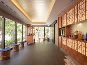 a hallway in a building with windows and stools at MIMARU Osaka Shinsaibashi East in Osaka