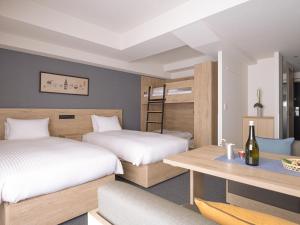 大阪的住宿－MIMARU OSAKA SHINSAIBASHI EAST，一间卧室配有两张床、一张桌子和一张双层床。