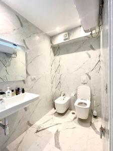 a white bathroom with a toilet and a sink at Durres Currila RELAX Beach Lifestyle in Durrës +55 photos