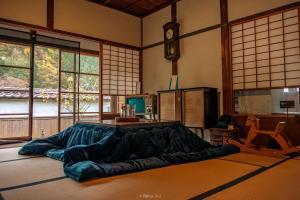 Cette chambre dispose d'un grand lit et de fenêtres. dans l'établissement Japan's oldest remaining company housing, à Ikuno