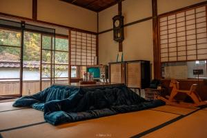 a room with a large bed in a room with windows at Japan's oldest remaining company housing in Ikuno