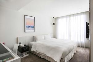 a bedroom with a large white bed and a window at CityInn Hotel Taipei Station Branch III in Taipei