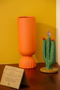 een oranje vaas op een tafel naast een cactus bij Hotel Vento Brasil in Paracuru