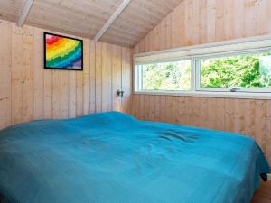 um quarto com uma cama azul numa parede de madeira em Holiday home Toftlund XLV em Toftlund
