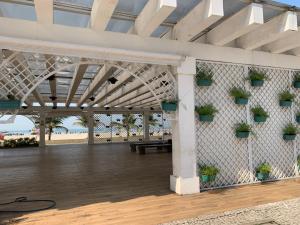 un padiglione con piante in vaso su un muro con la spiaggia di APARTAMENTO NA PRAIA GRANDE A 200 MÉTROS DA PRAIA, CONFORTÁVEL ESPAÇOSO WIFI 350 Mega TV Claro, ÓTIMA LOCALIZAÇÃO a Praia Grande
