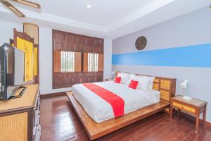 a bedroom with a bed and a television in it at Evergreen boutique Hua Hin in Hua Hin
