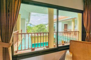 Habitación con balcón con vistas a la piscina. en Evergreen boutique Hua Hin, en Hua Hin