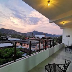 a balcony with chairs and a view of the mountains at Large and comfy apartment, near DT and Principal Beach! in Zihuatanejo