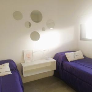 a bedroom with two beds and a nightstand and mirrors at HOMU DEP - Puerto deseado in Puerto Deseado
