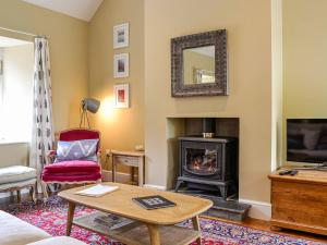 een woonkamer met een open haard en een televisie bij Rose Cottage in Blairgowrie