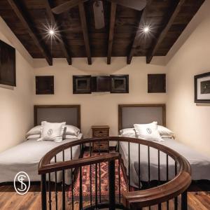 two beds in a room with a wooden ceiling at La Santísima Trinidad in Dolores Hidalgo