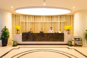 a lobby with two people standing at a reception desk at Muong Thanh Luxury Lang Son Hotel in Lạng Sơn