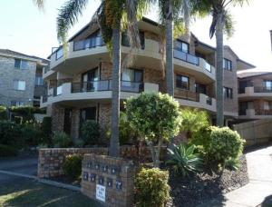 a building with palm trees in front of it at Renas Court, Unit 6, 72 Little Street in Forster