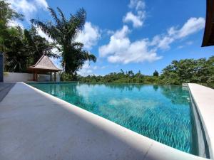 a swimming pool in a villa with blue water at Villa Tamaro Bali in Ubud