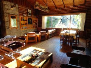 a living room with a table and chairs in a cabin at Hotel Angostura in Villa La Angostura
