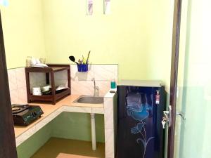 eine kleine Küche mit Spüle und Kühlschrank in der Unterkunft Lakromo Amed Homestay in Amed