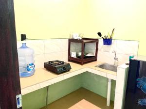 eine Küchentheke mit Spüle und Radio in der Unterkunft Lakromo Amed Homestay in Amed