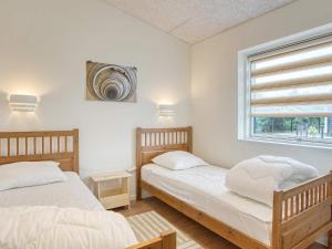 two twin beds in a room with a window at Holiday home Væggerløse CCXIII in Bøtø By