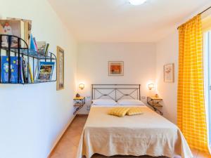 een slaapkamer met een bed met gele kussens erop bij Romantic cottage in San Feliciano with garden in San Feliciano