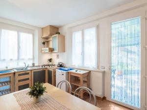 een keuken met een tafel en een aantal ramen en een wastafel bij Romantic cottage in San Feliciano with garden in San Feliciano