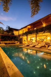 a swimming pool with lounge chairs and a house at VillaMag in Jericoacoara