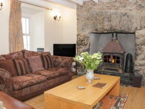 a living room with a couch and a fireplace at Bryn Dedwydd Farmhouse in Pentrefoelas