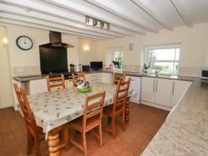 a kitchen and dining room with a table and chairs at Bryn Dedwydd Farmhouse in Pentrefoelas