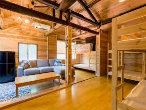 salon z kanapą i łóżkiem piętrowym w obiekcie 癒楽 伊豆大島 w mieście Oshima