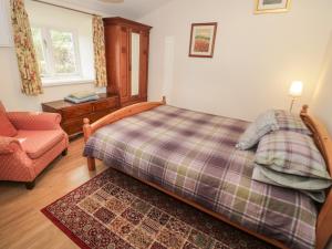 ein Schlafzimmer mit einem Bett, einem Sofa und einem Stuhl in der Unterkunft Bryn Dedwydd Farmhouse in Pentrefoelas