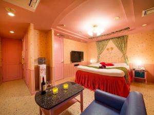 神戸市にあるホテルギャラリー（大人専用）のベッドとソファ付きのホテルルーム