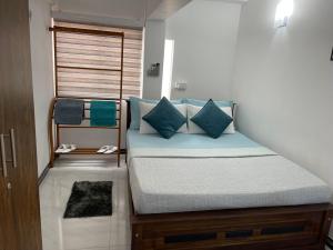 uma cama com almofadas azuis num quarto em SEBASTIAN TRANSIT KATUNAYAKE em Katunayaka