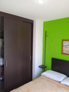 um quarto com uma parede verde e uma porta em Guaduales del cafe 211B em Montenegro