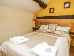 a bedroom with a bed with towels on it at The Cottage at Graysondale Farm in Cockermouth