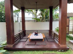 una veranda con tavolo su una terrazza in legno di Villa La Vimala a Gadok 1